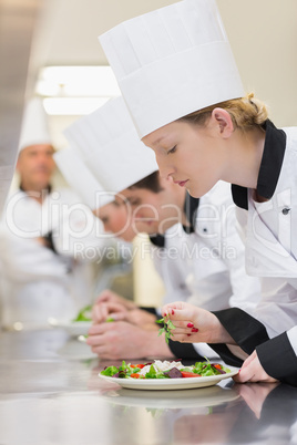 Chef's applying finishing touches to salads