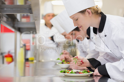 Chef's finishing their salads in culinary class