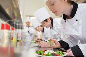Chef finishing her salad in culinary class