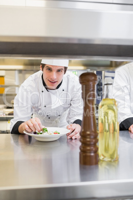 Chef looking up from garnishing salad