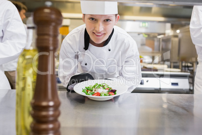 Happy chef presenting her salad