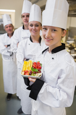 Smiling chef holding fruit plate