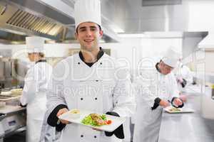 Happy chef holding salmon dish