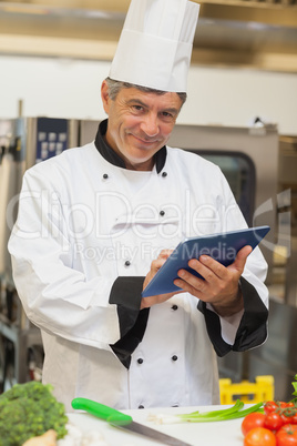 Chef using digital tablet and smiling
