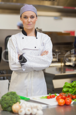 Chef standing beside chopping board and vegetables