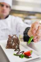 Chef applying finishing touch to desert