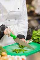 Chef slicing up scallions
