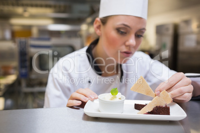 Chef garnishing a slice of cake