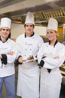 Three happy Chef's presenting a cake