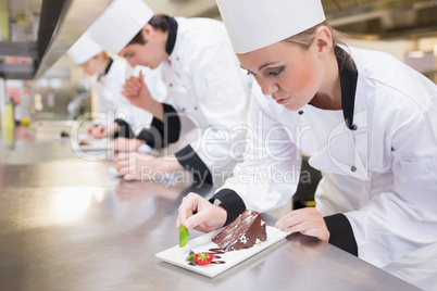 Chef's team garnishing slices of cake