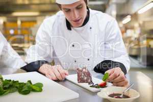 Chef putting mint leaf with his dessert