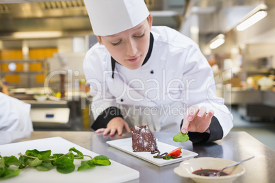 Chef putting mint with her chocolate cake