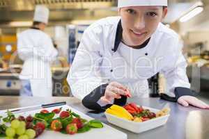 Happy chef preparing fruit salad