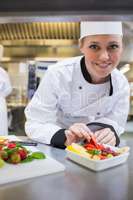 Smiling chef finishing the fruit salad