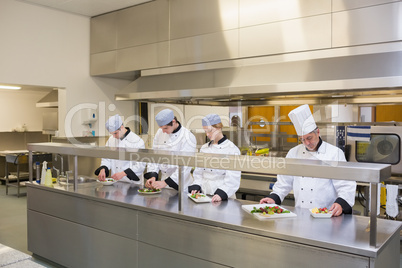 Four Chef's preparing plates