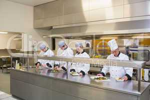 Four Chef's preparing plates