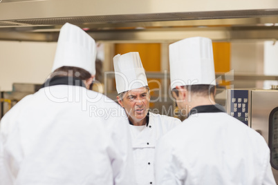 Angry head chef scolding employees