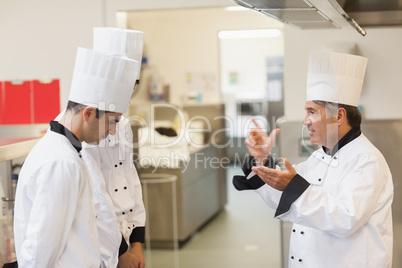 Upset head chef scolding employees