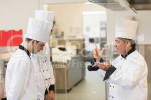 Upset head chef scolding employees