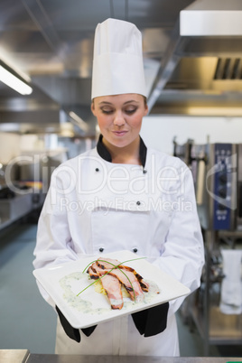 Smiling chef looking at her plate