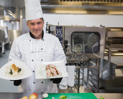 Chef holding two plates in the kitchen