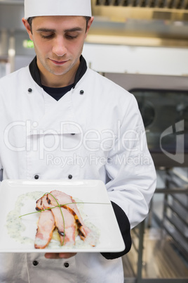 Chef looking down at his chicken dish