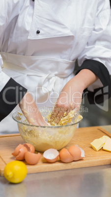 Chef mixing dough with hands