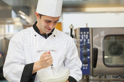 Smiling cook mixing batter