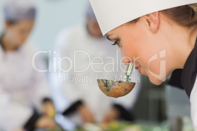 Smiling chef smelling the soup