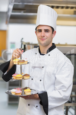 Baker holding tiered cake tray