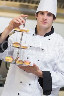 Baker presenting tiered cake tray