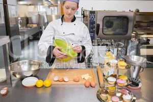 Woman mixing dough in kitchen