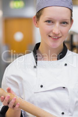 Woman holding rolling pin while smiling