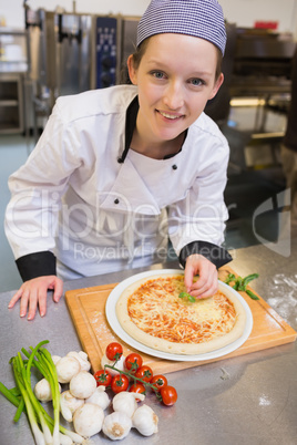 Smiling chef preparing pizza
