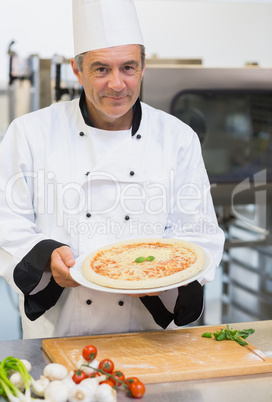 Cheerful chef presenting pizza