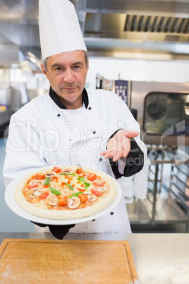 Cook presenting his pizza