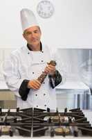 Smiling chef holding a pepper mill