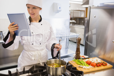 Female chef using tablet pc while cooking