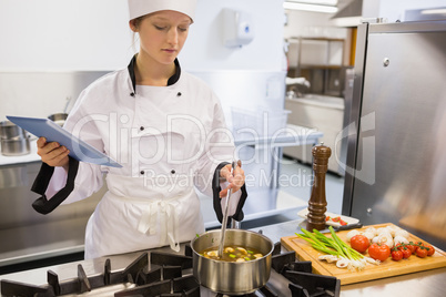 Woman viewing tablet pc while cooking