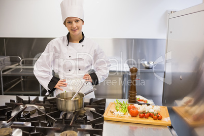Chef standing at stove while smiling