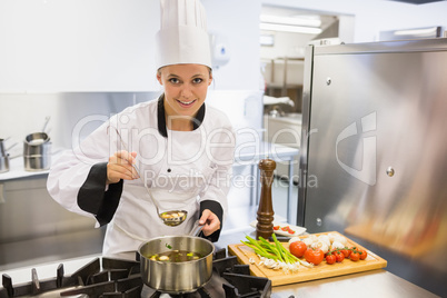 Woman tasting soup while cooking