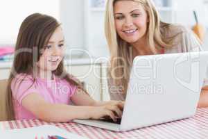 Little girl typing on laptop
