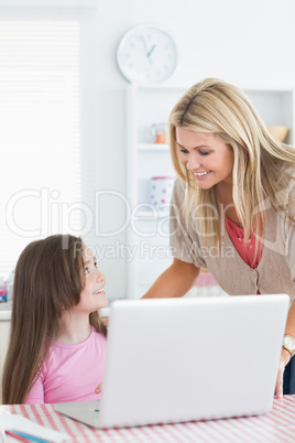 Woman and child smiling at each other in kitchen