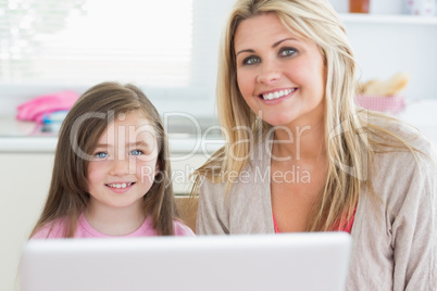 Woman and child sitting and smiling with laptop