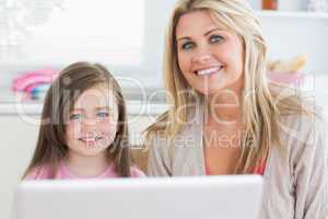 Woman and child sitting and smiling with laptop
