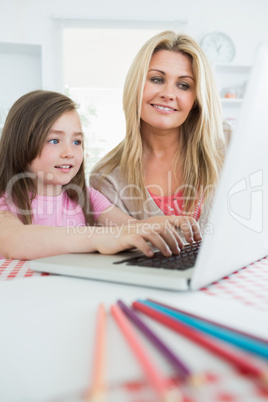 Mother watching child typing