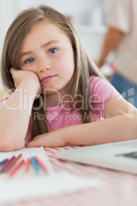 Girl sitting at kitchen looking bored