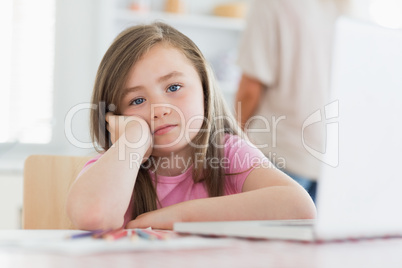 Child sitting at the table looking bored
