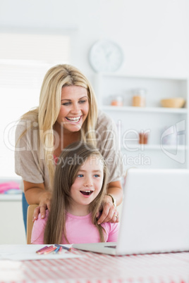 Woman and daughter sitting at the table at the kitchen
