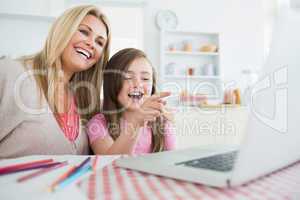 Woman and child sitting at the kitchen table laughing